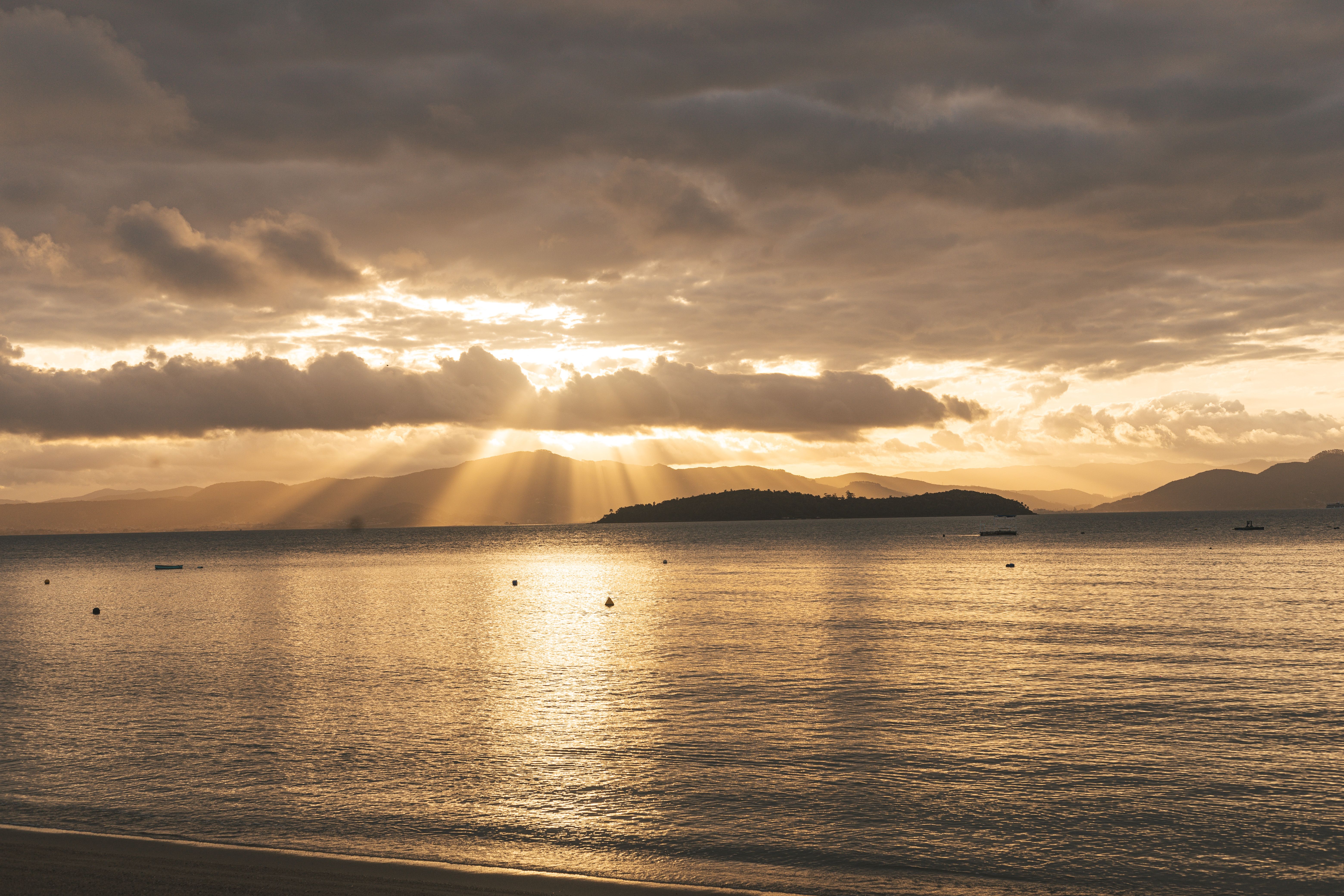 Golden sunset over a tranquil beach in Florianópolis, Brazil.