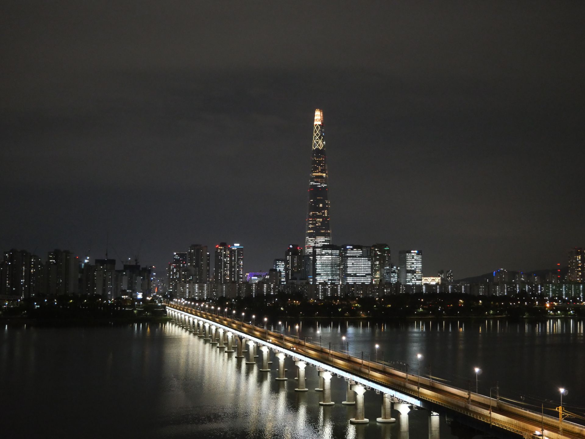Night view of Seoul's stunning skyline with the iconic Lotte World Tower and Han River.
