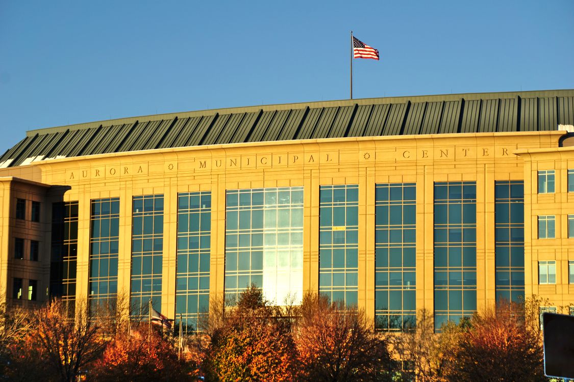 Aurora municipal center building with American flag representing local government transparency