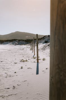 Serene beach with wooden posts and sand dunes in Esperance, perfect for relaxation.
