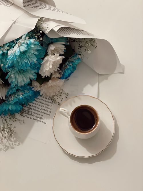 Free A beautiful mix of blue and white flowers next to a cup of Turkish coffee, creating a serene setting. Stock Photo