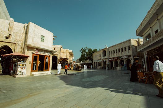 Historic market street with traditional architecture and people in Middle Eastern attire.