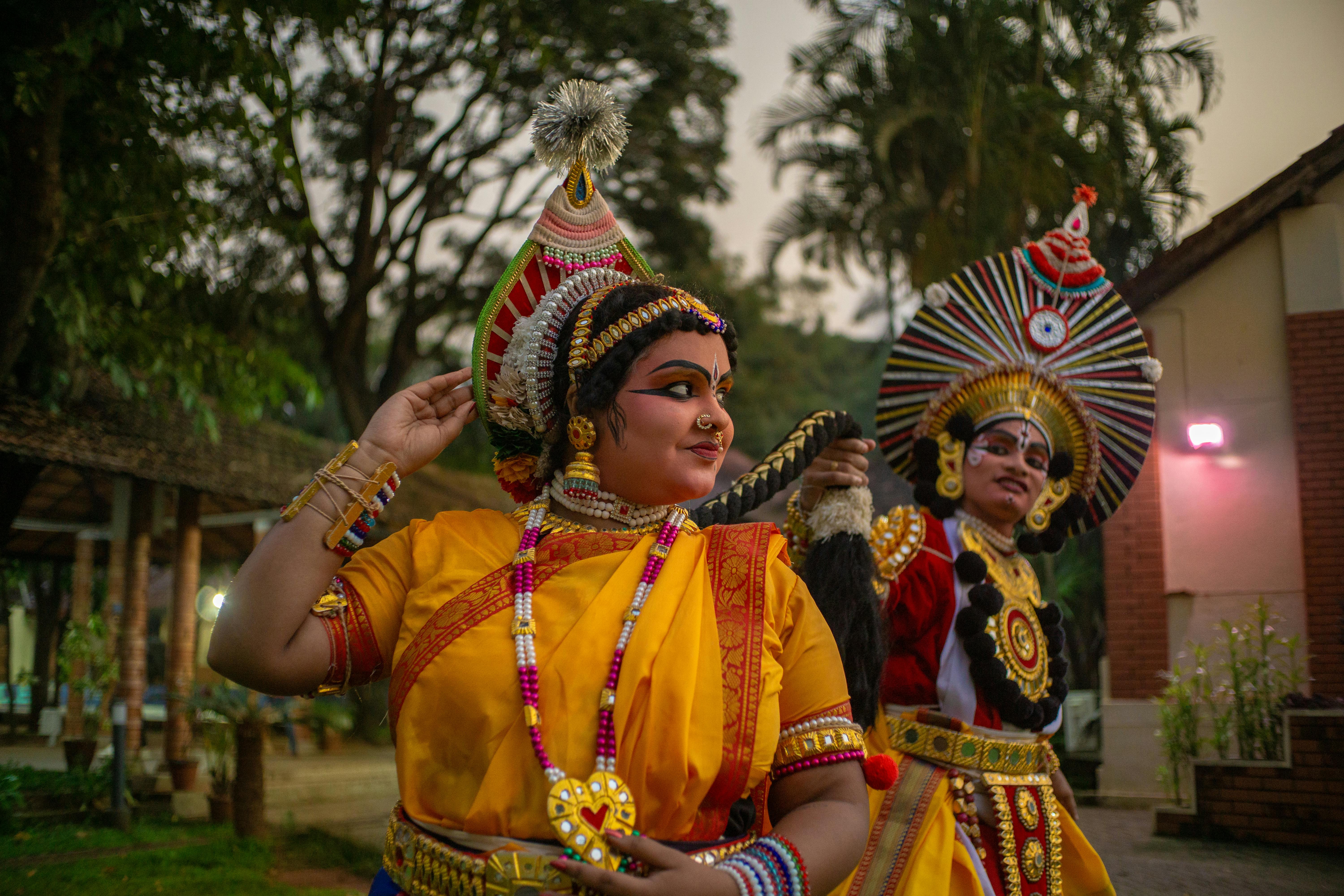 Gratis To Yakshagana-artister i traditionelle kostumer og makeup, der viser kulturarven i udendørs omgivelser. Lagerfoto
