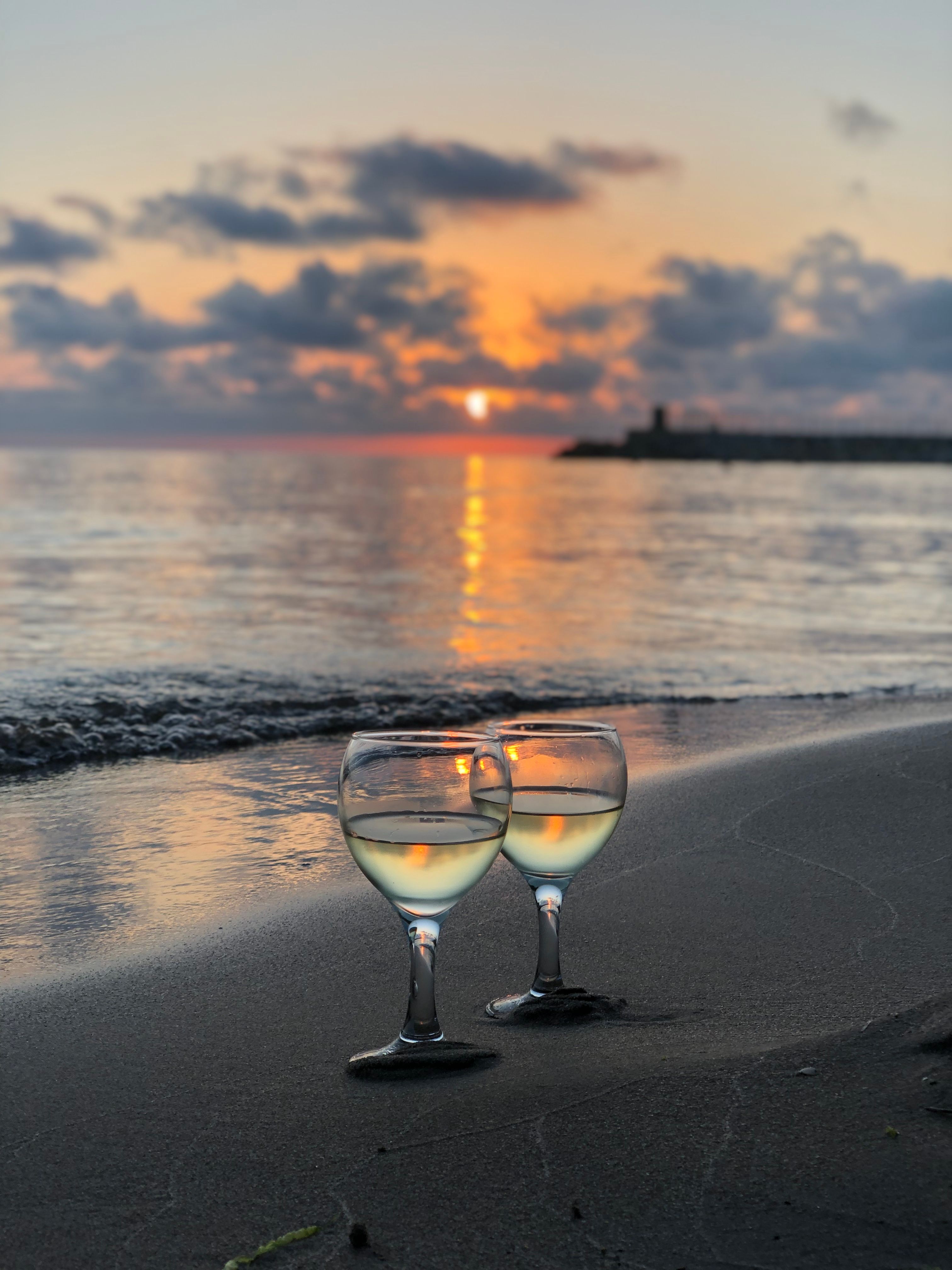 Romantic Beach Sunset with Wine Glasses  Free Stock Photo