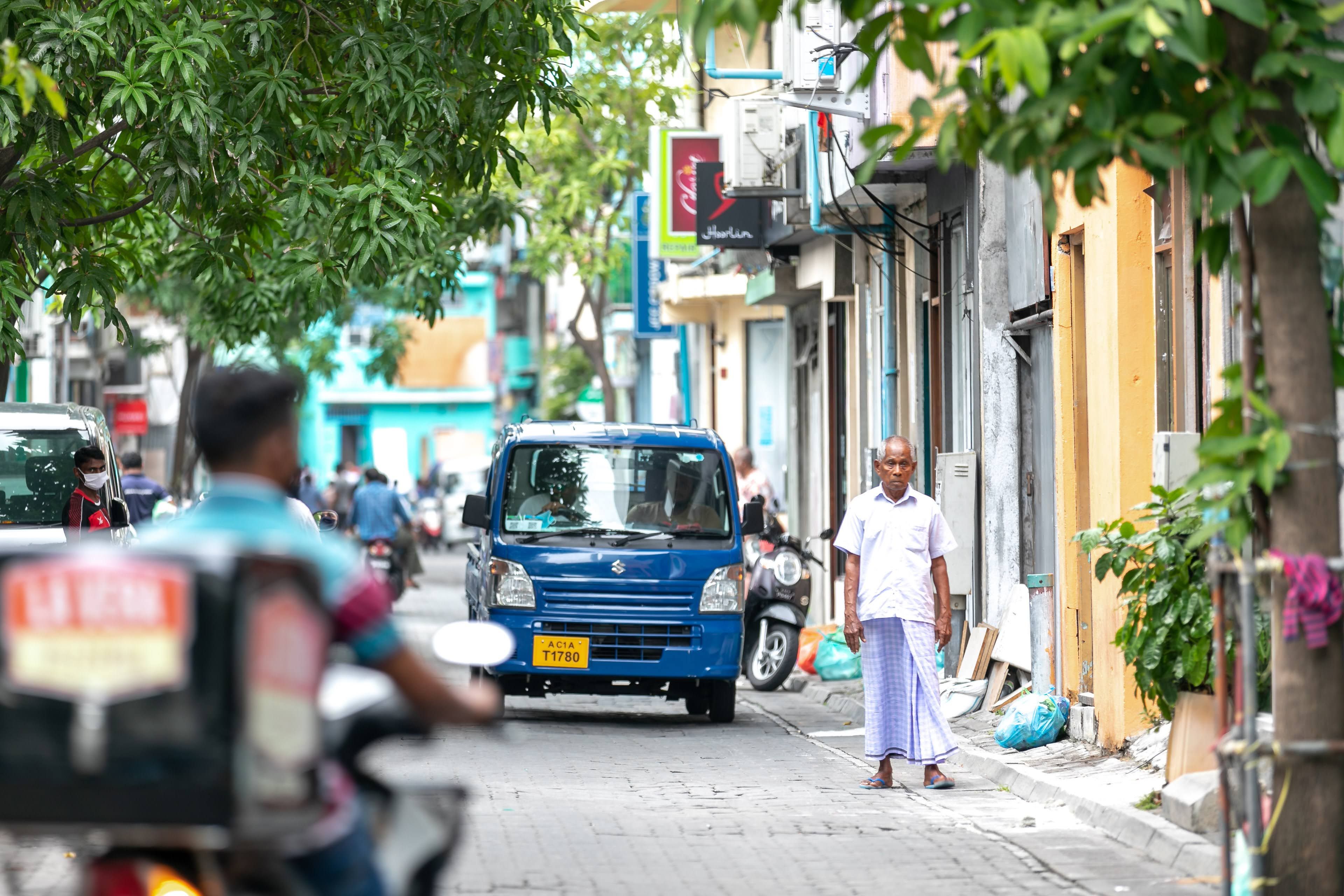 A bustling street in Malé, Maldives, featuring a variety of daily life activities and local architecture.