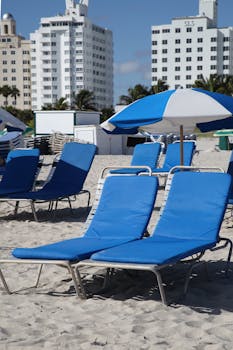 Relax on blue beach chairs with umbrellas on Miami Beach, Florida.