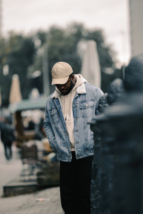 Free A young man in casual attire strolls through an urban environment, exemplifying street style fashion. Stock Photo