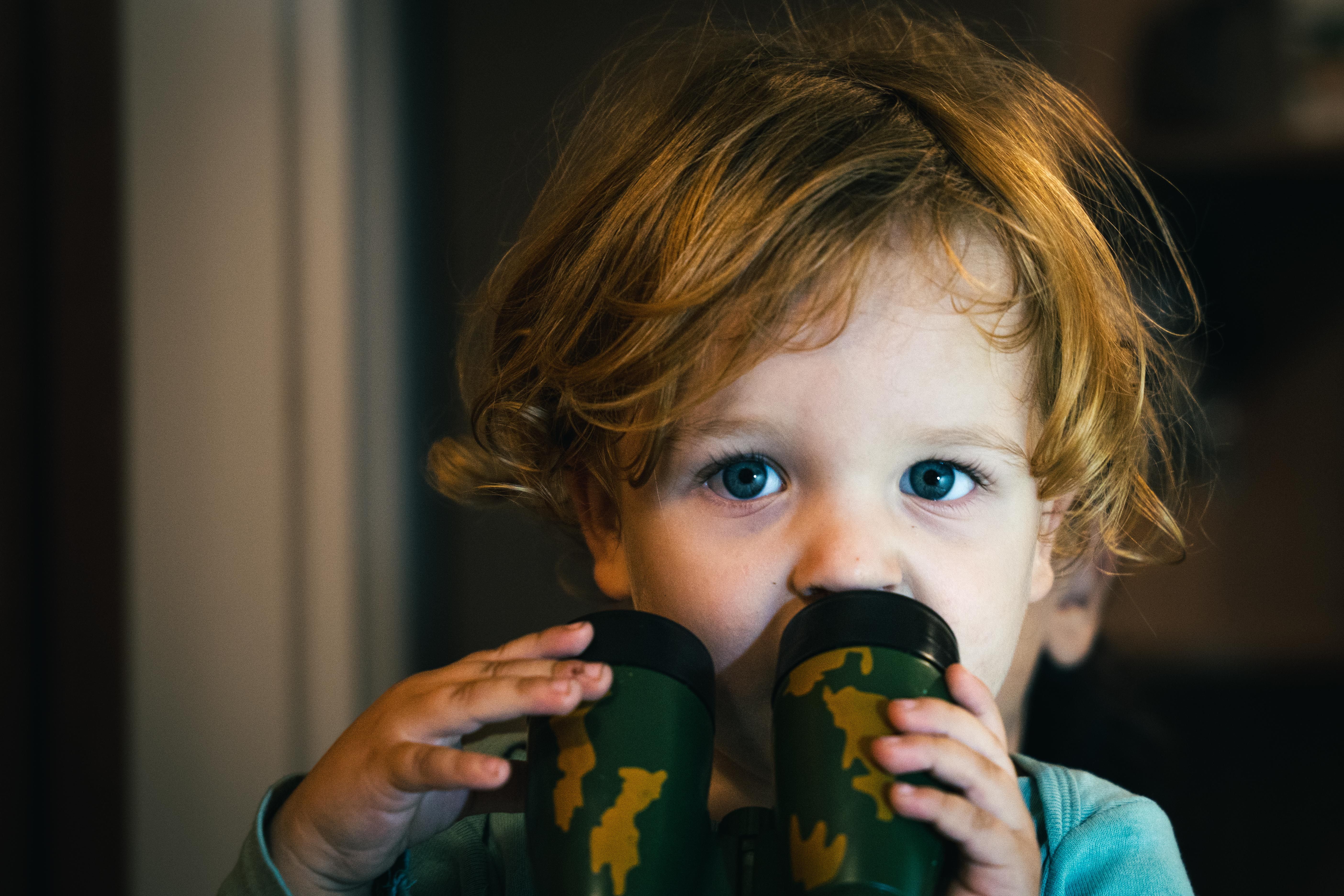 Curious child with binoculars, exploring and discovering indoors.