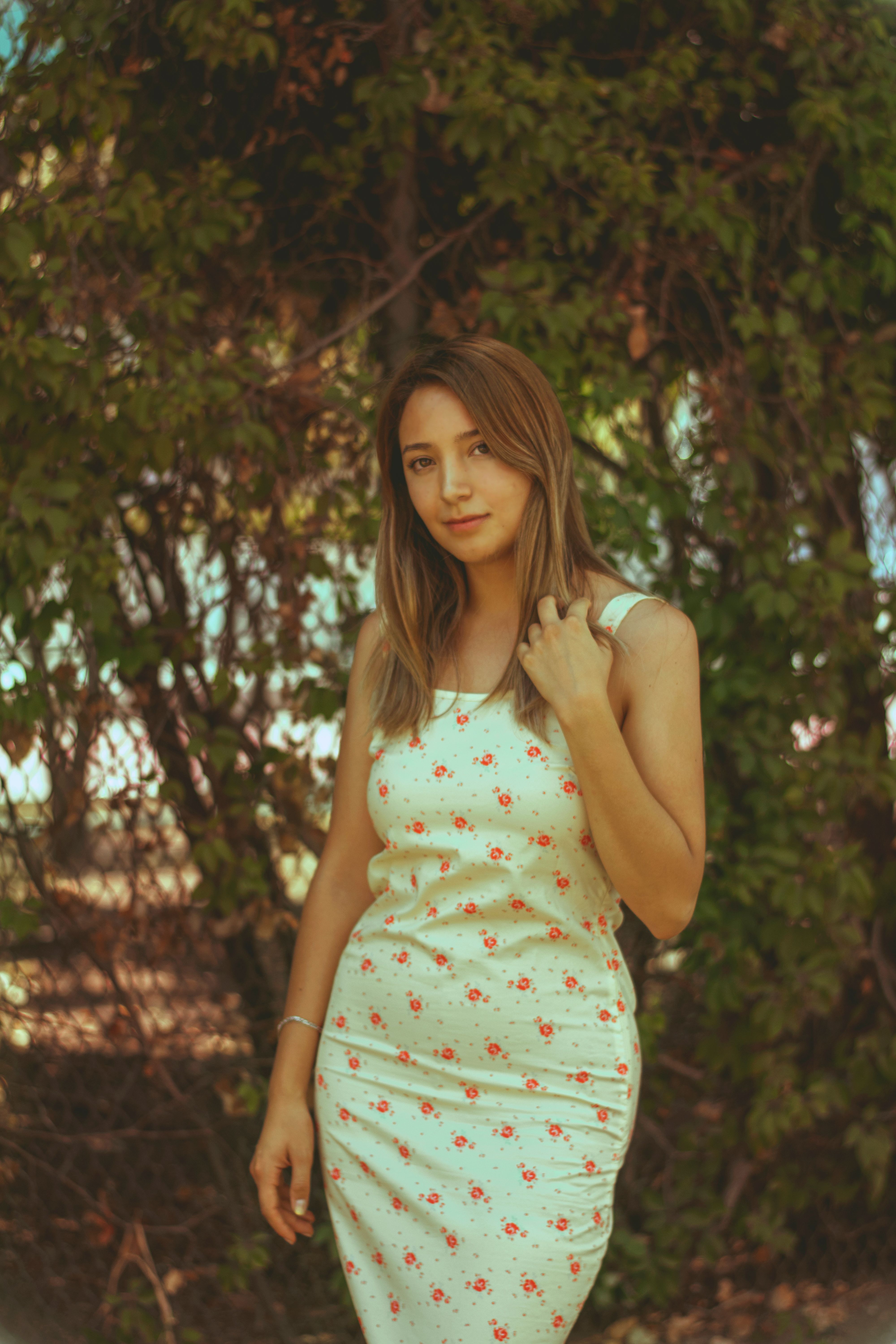 Young Woman Posing in Floral Dress Outdoors · Free Stock Photo