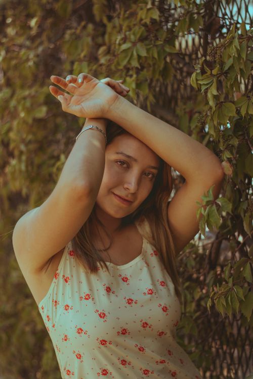 Free Charming young woman posing outside with green foliage background. Stock Photo