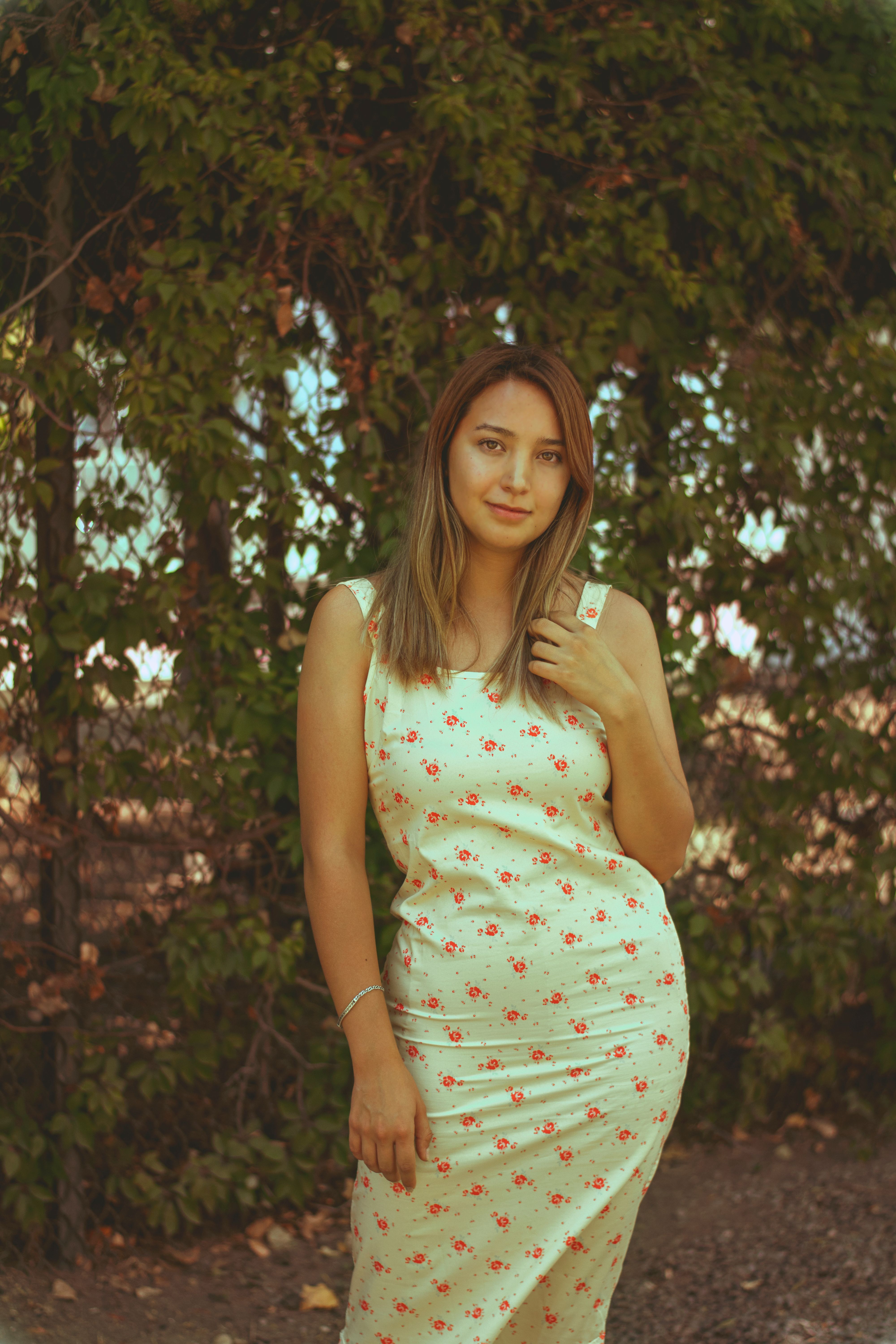 Woman in Floral Dress Posing Outdoors · Free Stock Photo