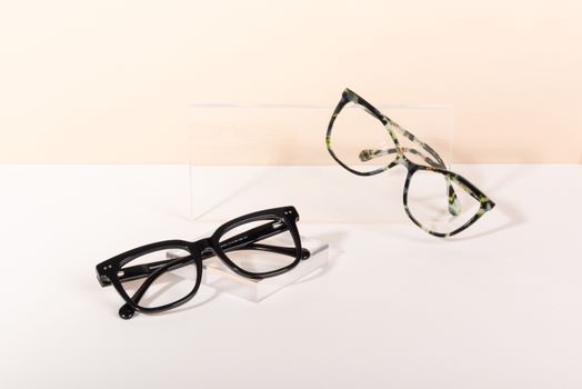 Modern eyeglasses on a minimalist backdrop showcasing black and tortoiseshell frames.