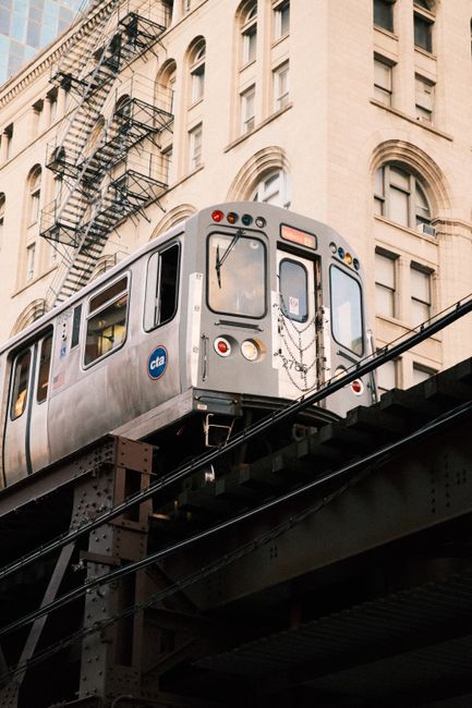 Chicago CTA train travels on elevated tracks past historical buildings.