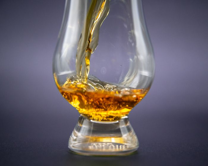 Golden whiskey being poured into a glass