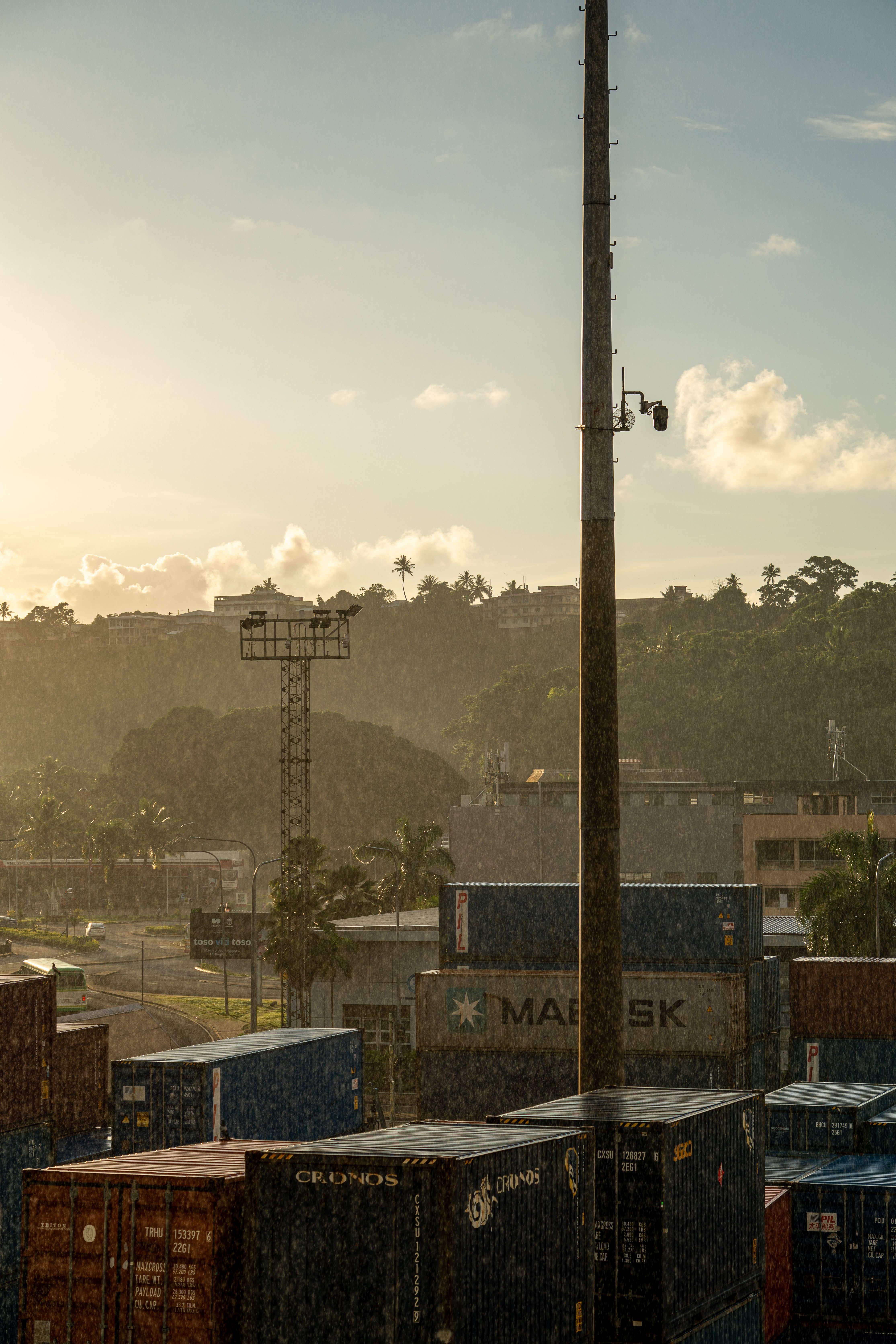 View of shipping containers at Suva harbour under a rainy sunset sky, Central Division, Fiji.