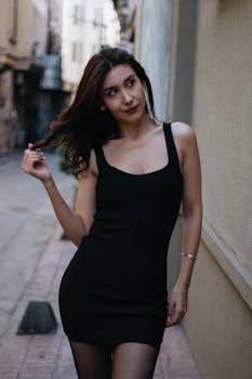 Elegant portrait of a woman in a black dress in a narrow İstanbul street.