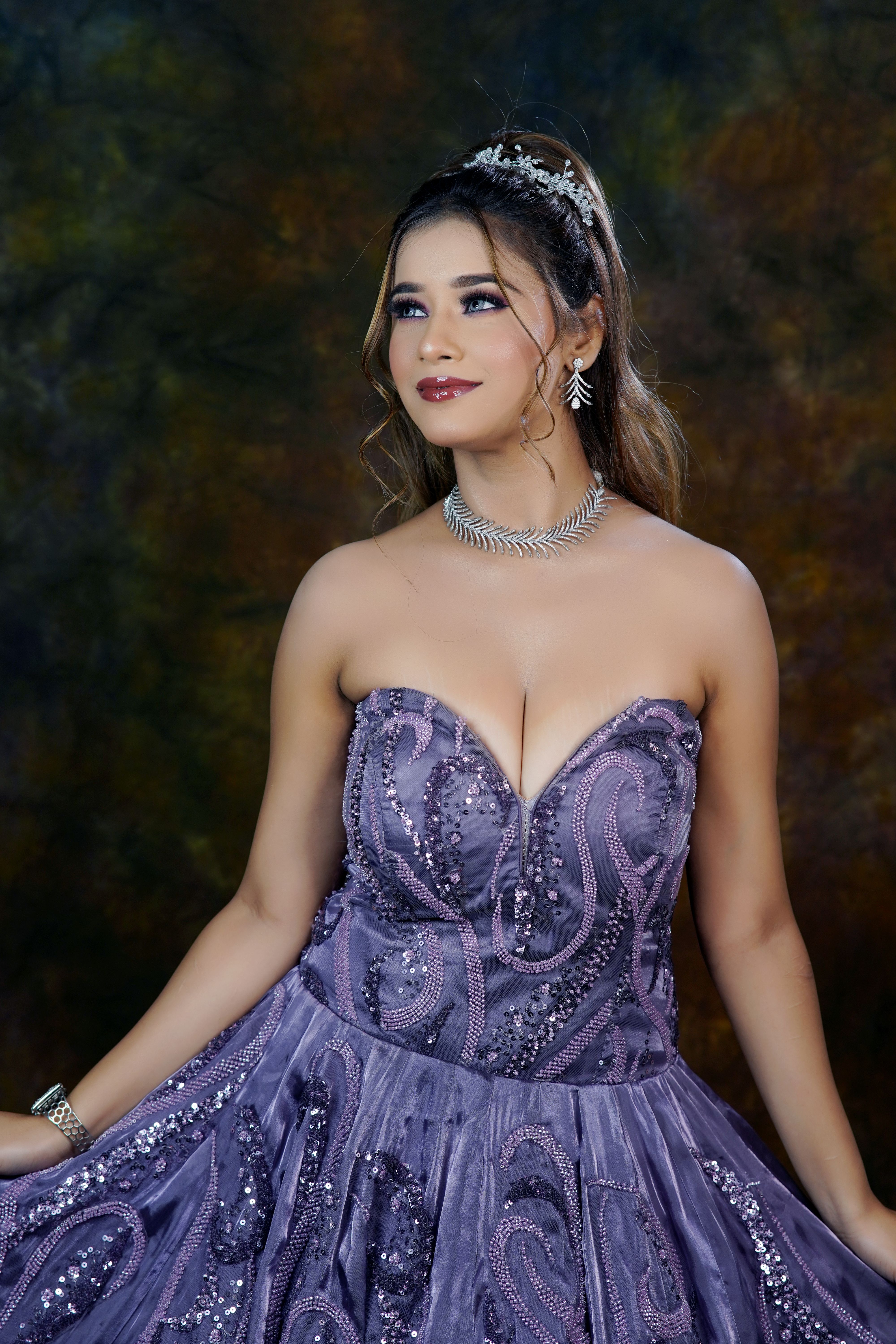 A beautiful woman in a purple evening gown looks serene and elegant