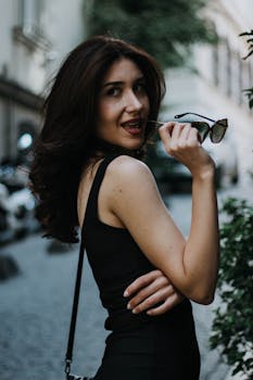 Elegant woman posing with sunglasses in İstanbul's lively streets.