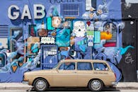 在佛罗里达州迈阿密，一辆老爷车停在一幅充满活力的街头艺术壁画旁