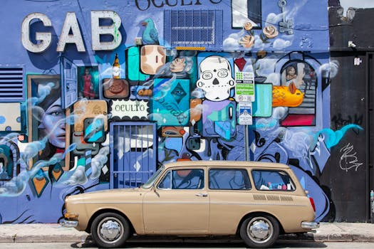 A vintage car parked against a vibrant street art mural in Miami, Florida.