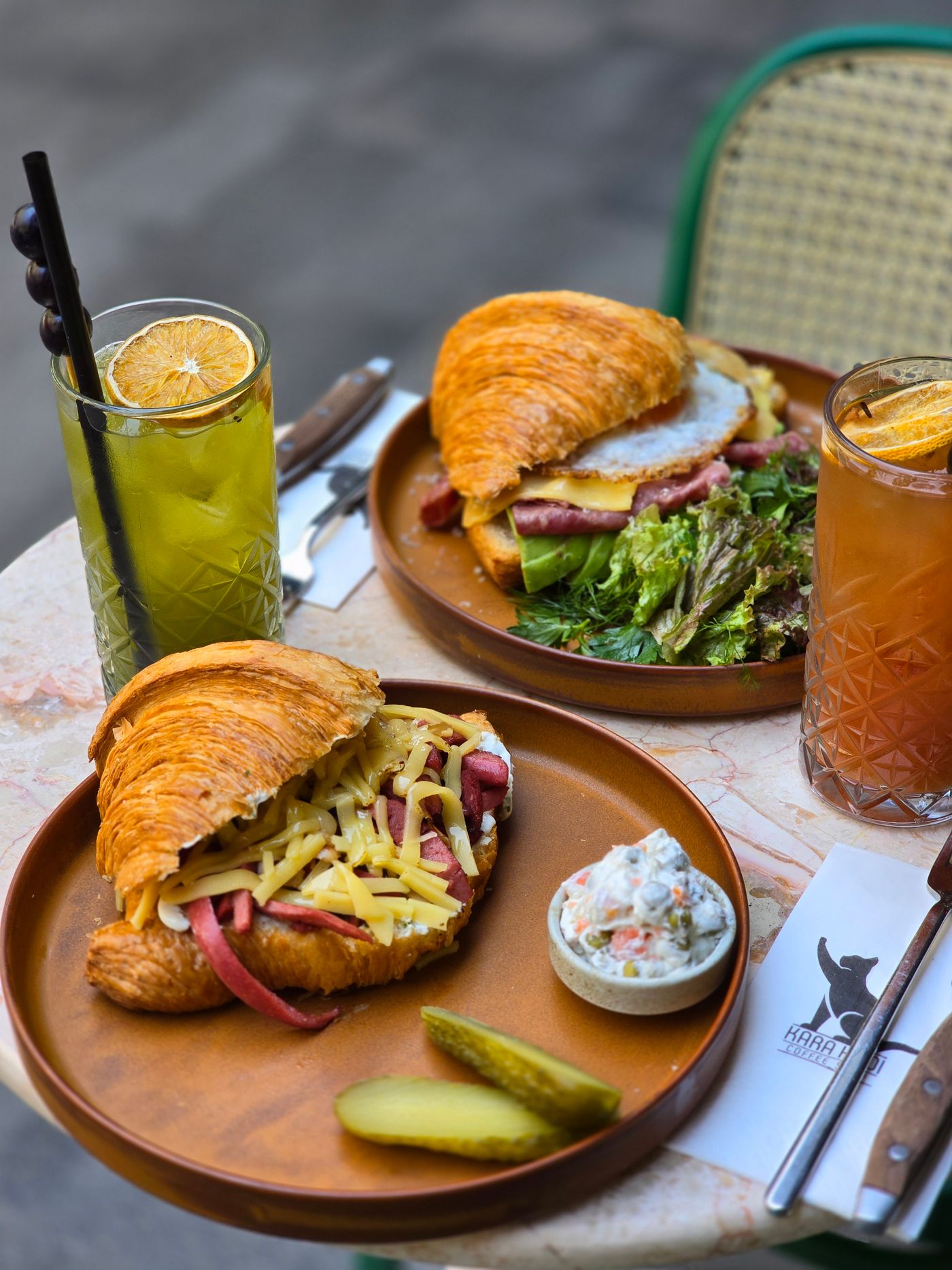 Croissant sandwich dan minuman di meja cafe