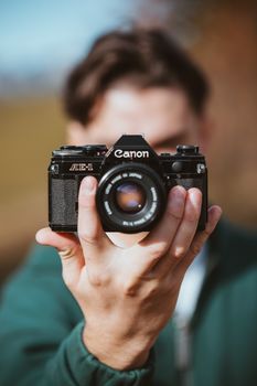 Close-up of a vintage film camera held by a person in Trentino-Südtirol, Italy.