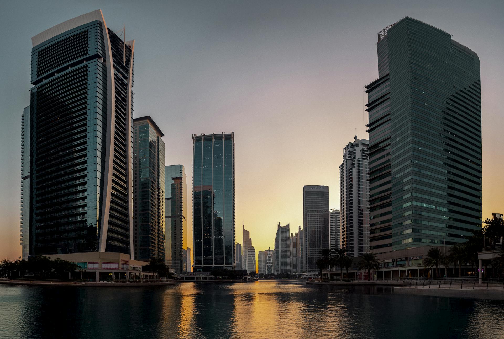 Stunning view of Dubai's modern skyline reflecting at sunset, showcasing iconic architecture.