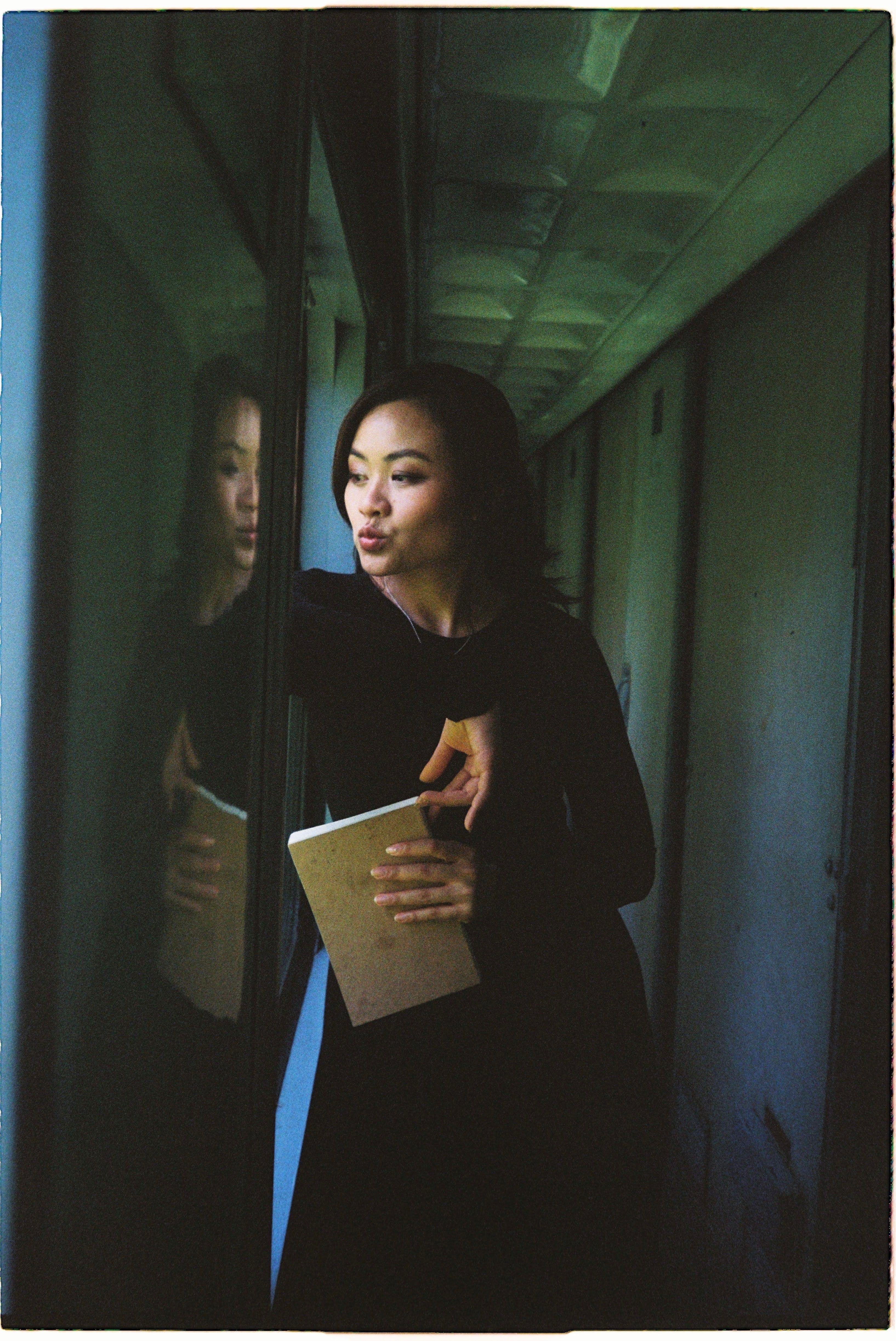Contemplative Woman Holding Notebook on Train · Free Stock Photo