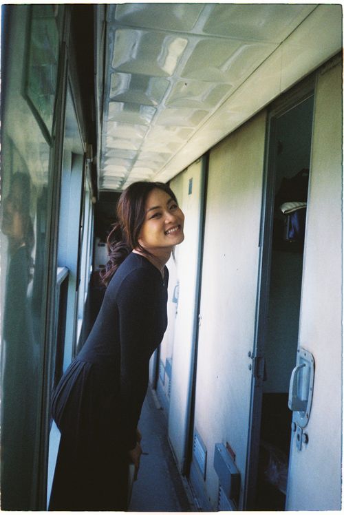 Free Young woman smiling inside train corridor. Travel happiness vibes. Stock Photo