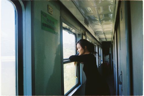 Free A woman looks outside the train window during a scenic daytime journey, capturing a moment of reflection. Stock Photo
