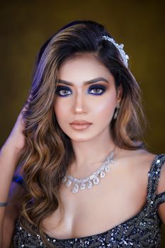 Stunning portrait of a woman wearing sparkly jewelry and elegant makeup.