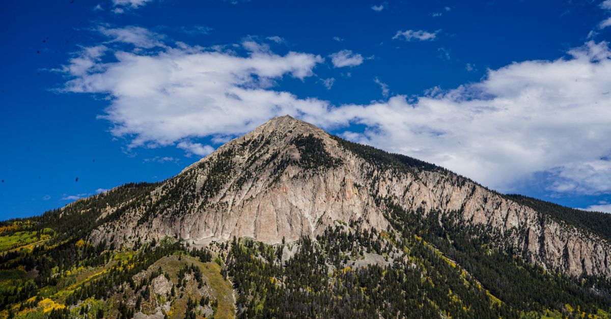 Stunning view of Crested Butte with autumn foliage under a bright blue sky.