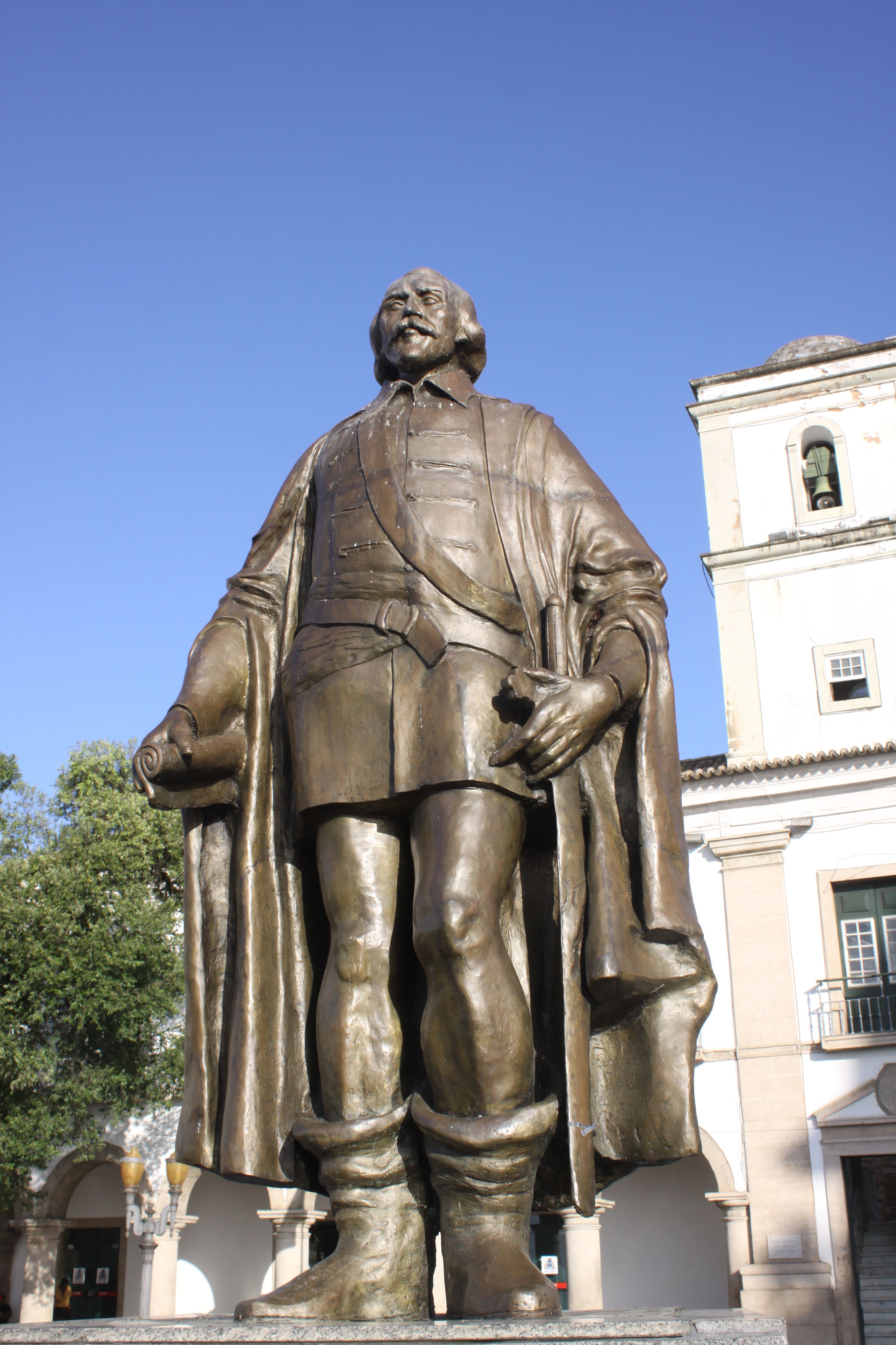 Bronze statue of a historic figure in Salvador, Bahia, Brazil, showcasing colonial architecture.