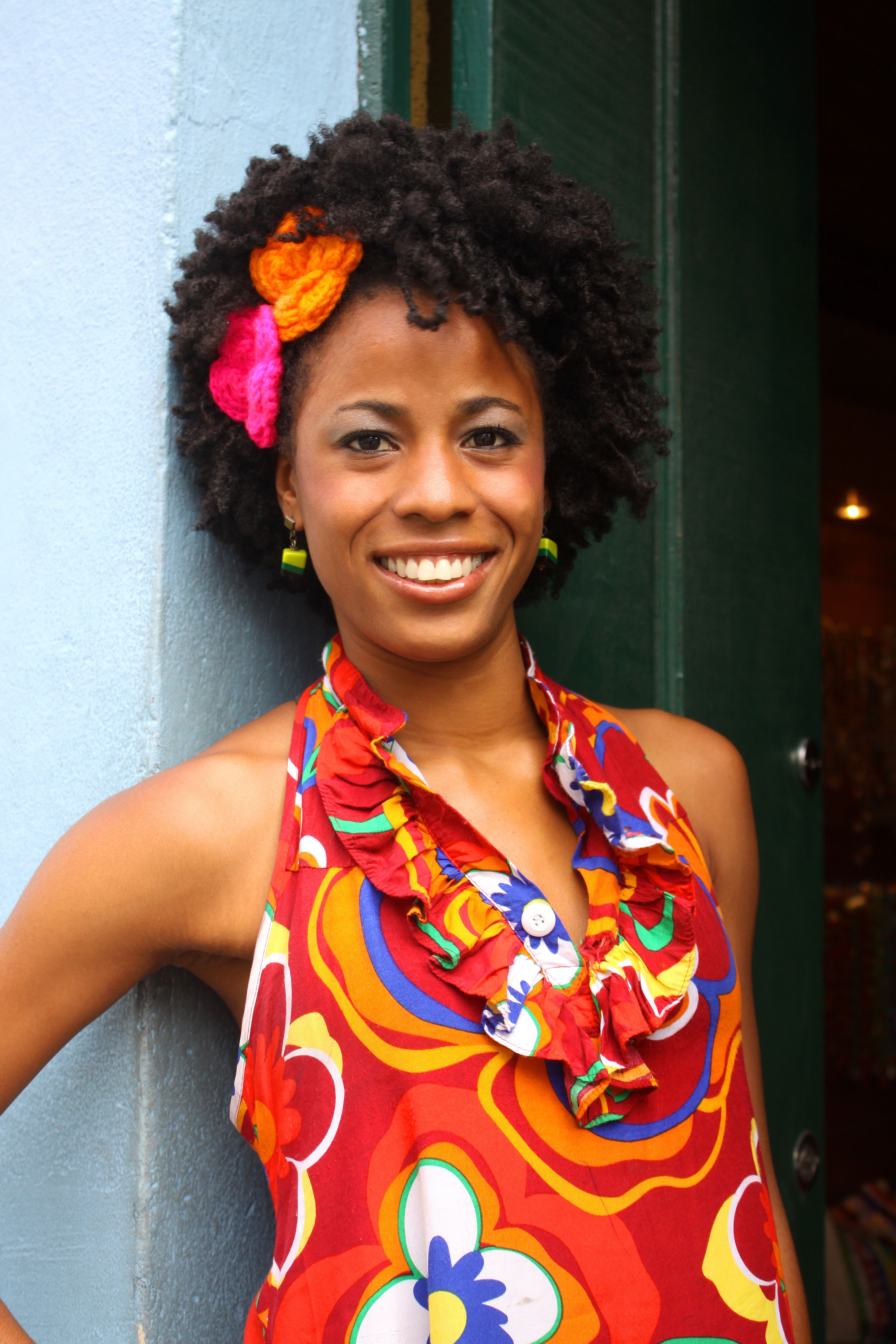Smiling woman in vibrant floral dress with Afro hairstyle in Salvador, Brazil