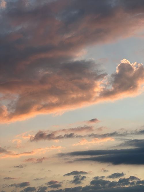Free Dramatic sky with vibrant sunset hues and fluffy clouds, creating a serene atmosphere. Stock Photo