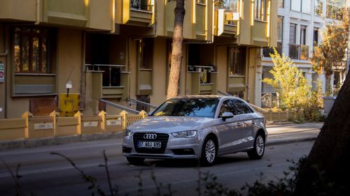 Free A silver Audi parked on a city street during a sunny day, showcasing urban lifestyle. Stock Photo