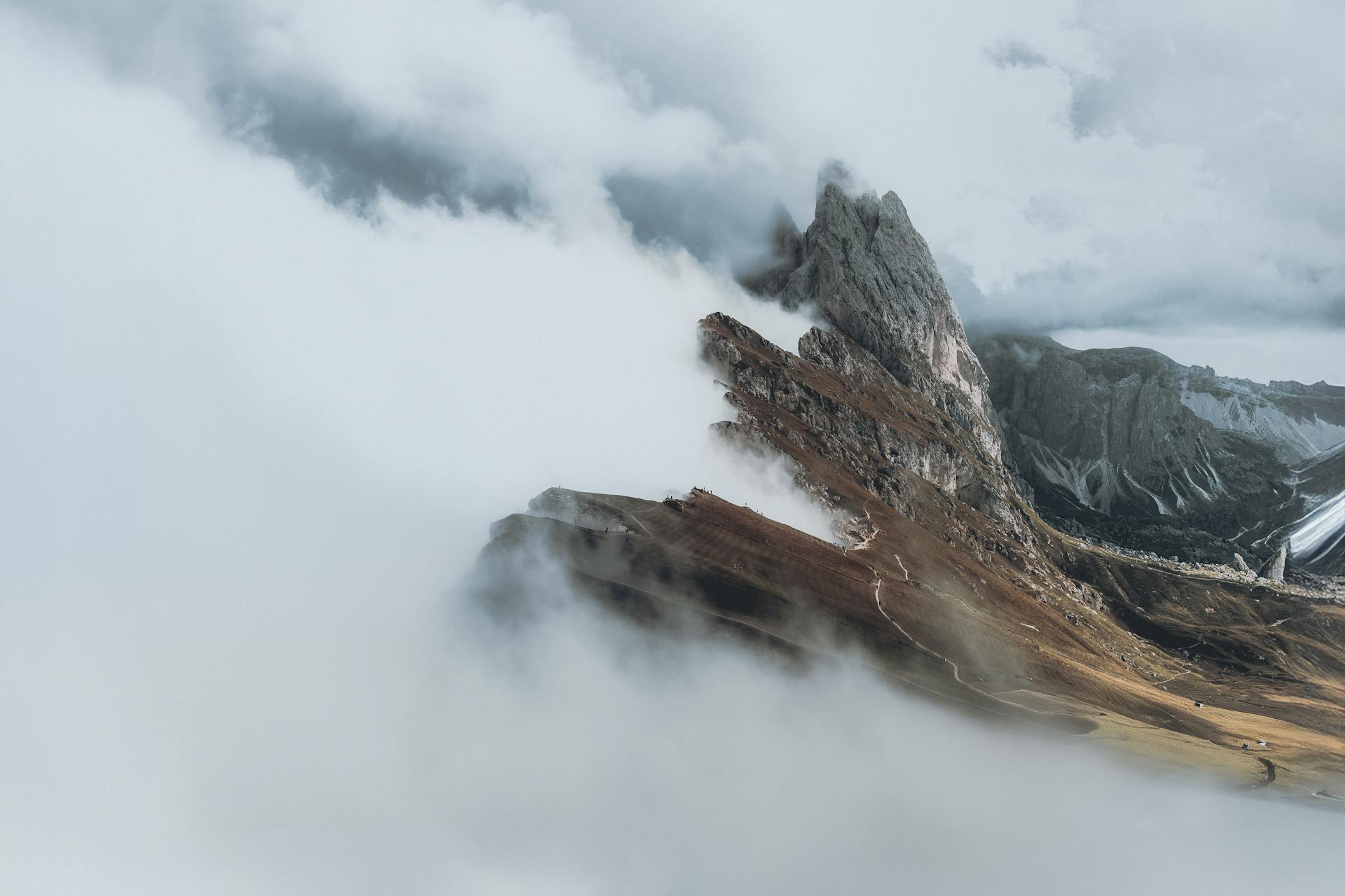 A breathtaking view of a mountain peak surrounded by clouds, capturing serenity and elevation.