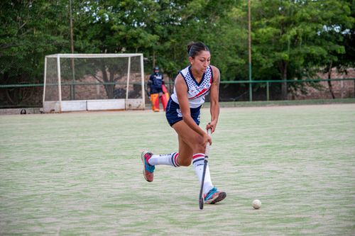 Free Captivating image of a female hockey player striking the ball on an outdoor field, showcasing athleticism and focus. Stock Photo