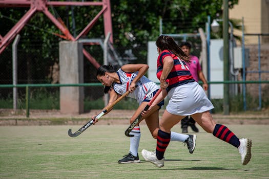 Intense game of women's field hockey showcasing determination and skill.