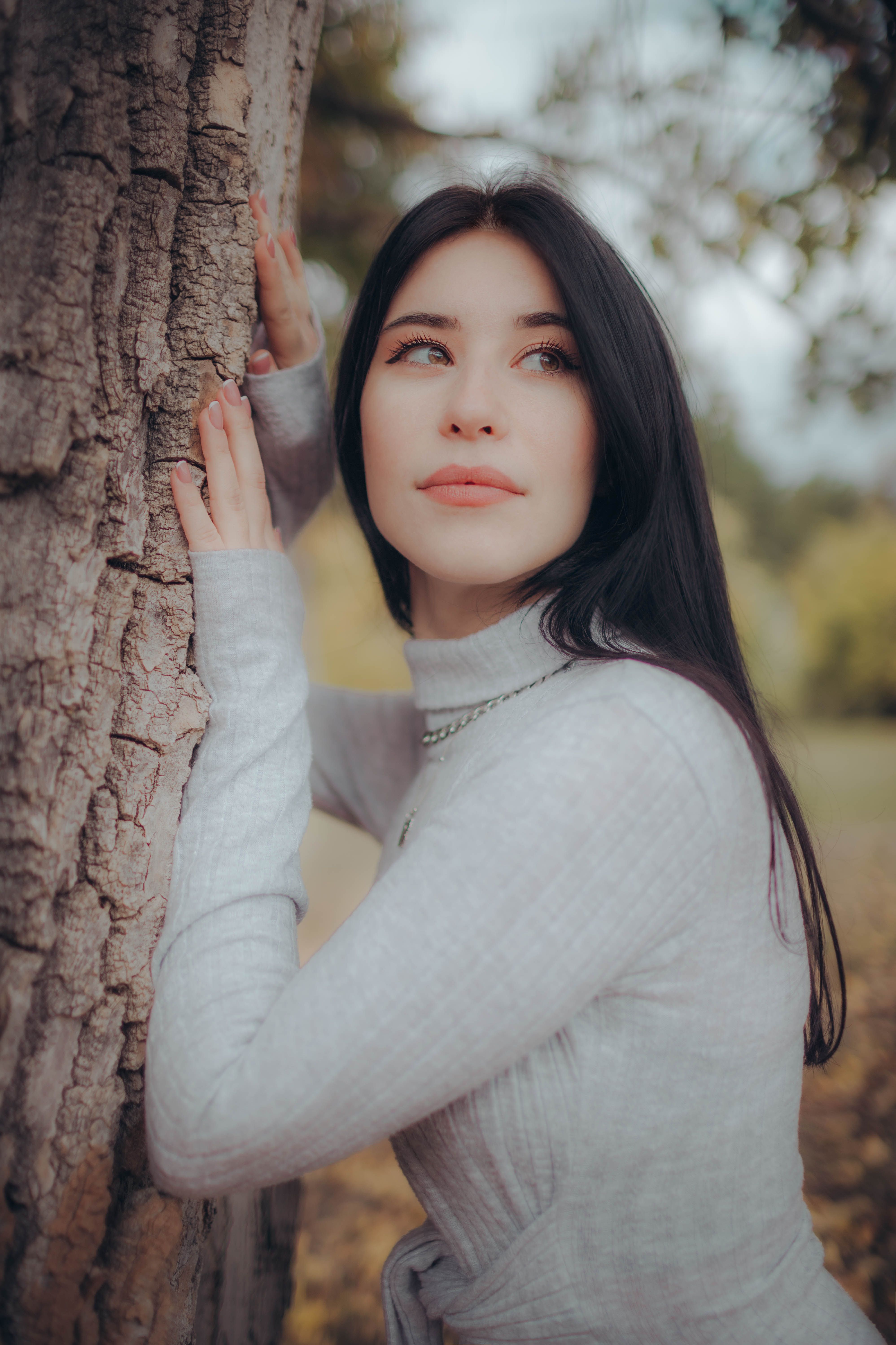 Woman in cozy sweater embracing nature outdoors