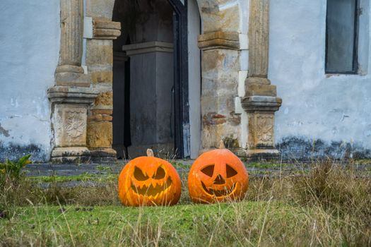 Two carved pumpkins sit by an old building in Guasca, Colombia.