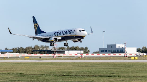 A Ryanair jetliner lands on the runway at Hamburg Airport, captured in daylight.