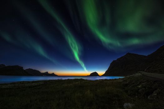 Beautiful aurora borealis illuminating the night sky over Nordland, Norway's rugged coastline.