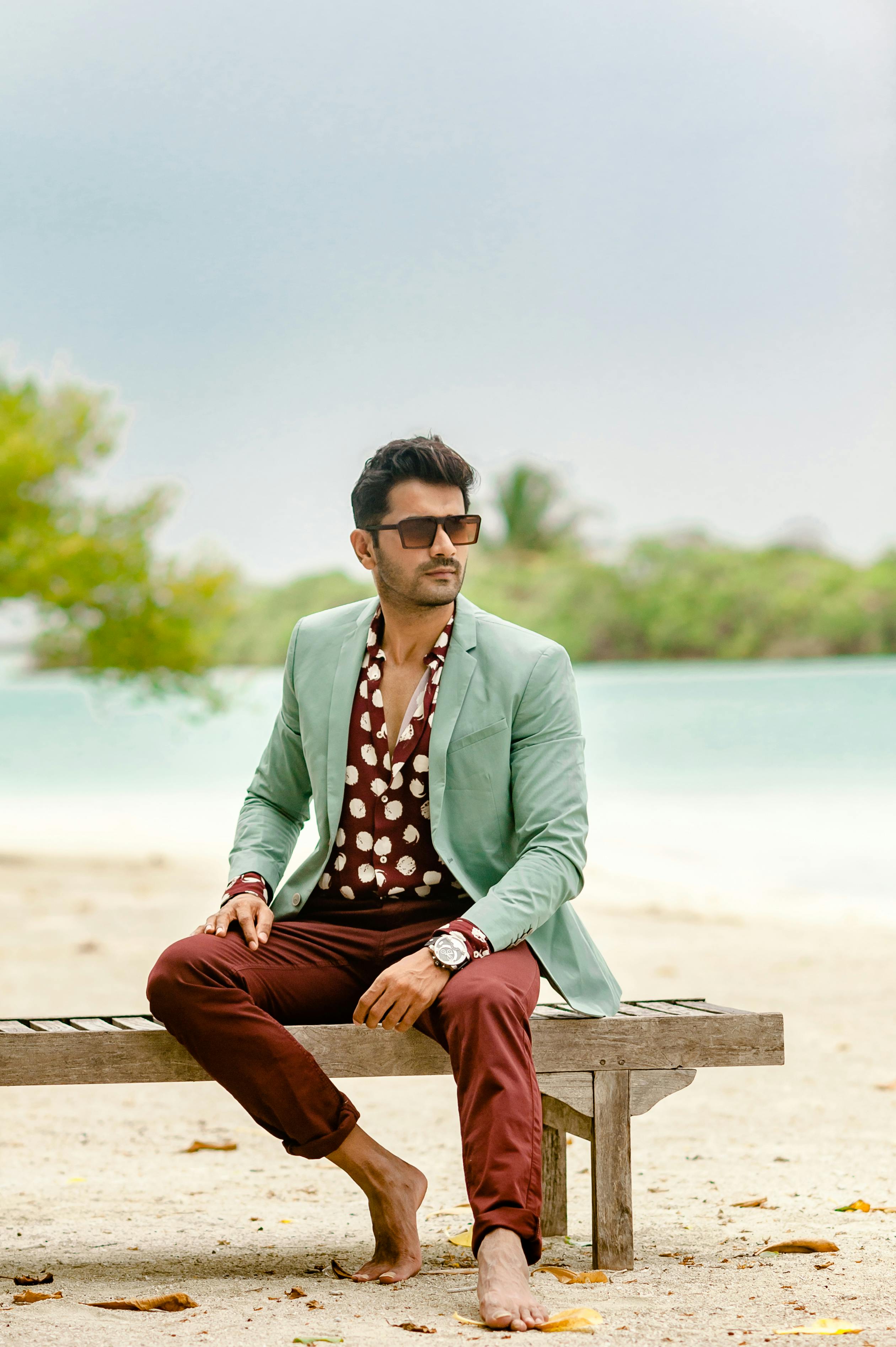 Fashionable male posing on a sunny beach in Maldives wearing a stylish outfit.