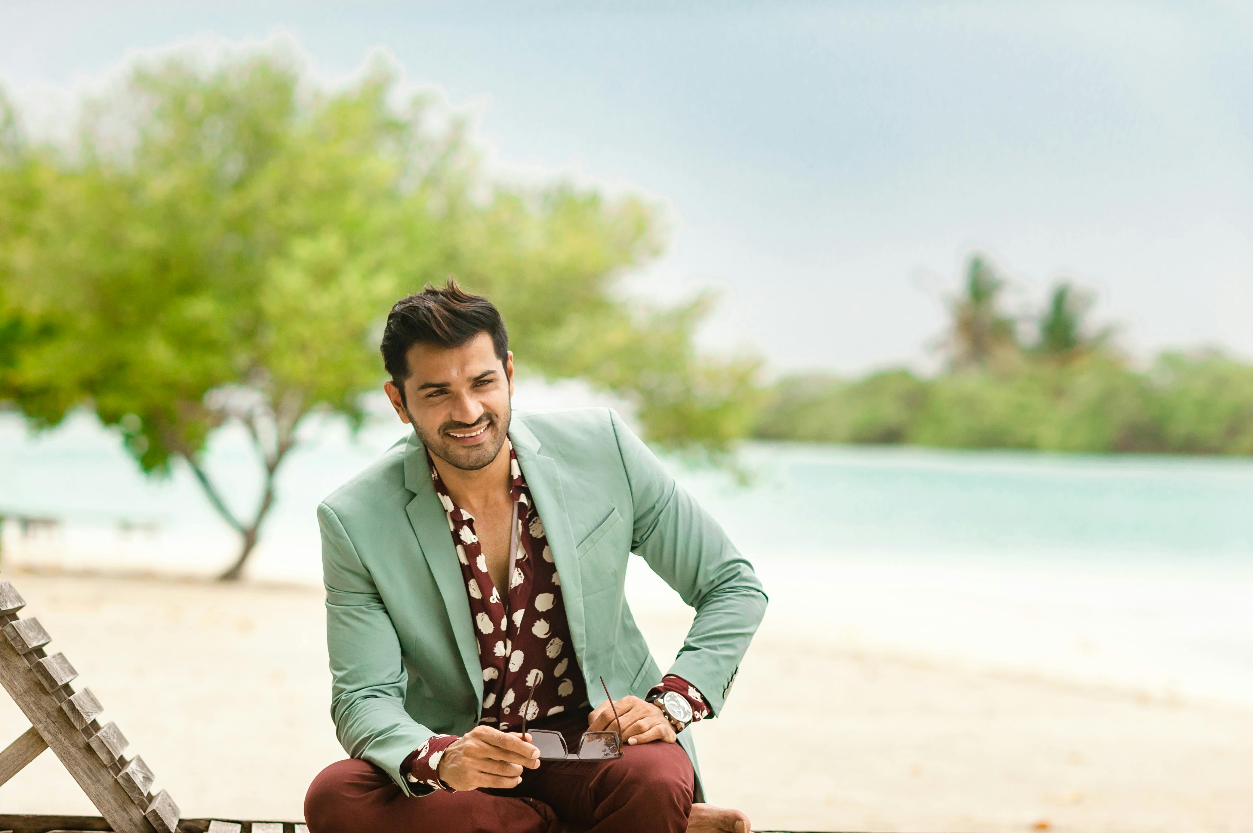 A fashionable man enjoying a tropical vacation on a pristine Maldivian beach.
