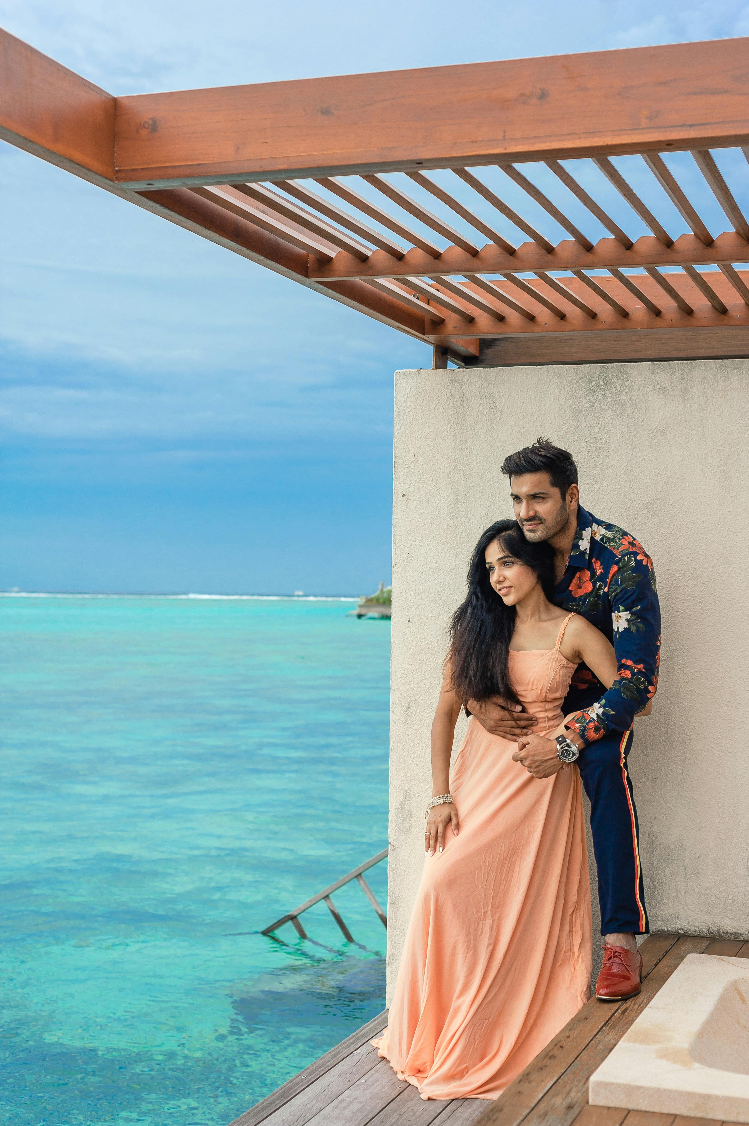 Stunning photoshoot of a couple at a luxury resort in the Maldives with ocean views.
