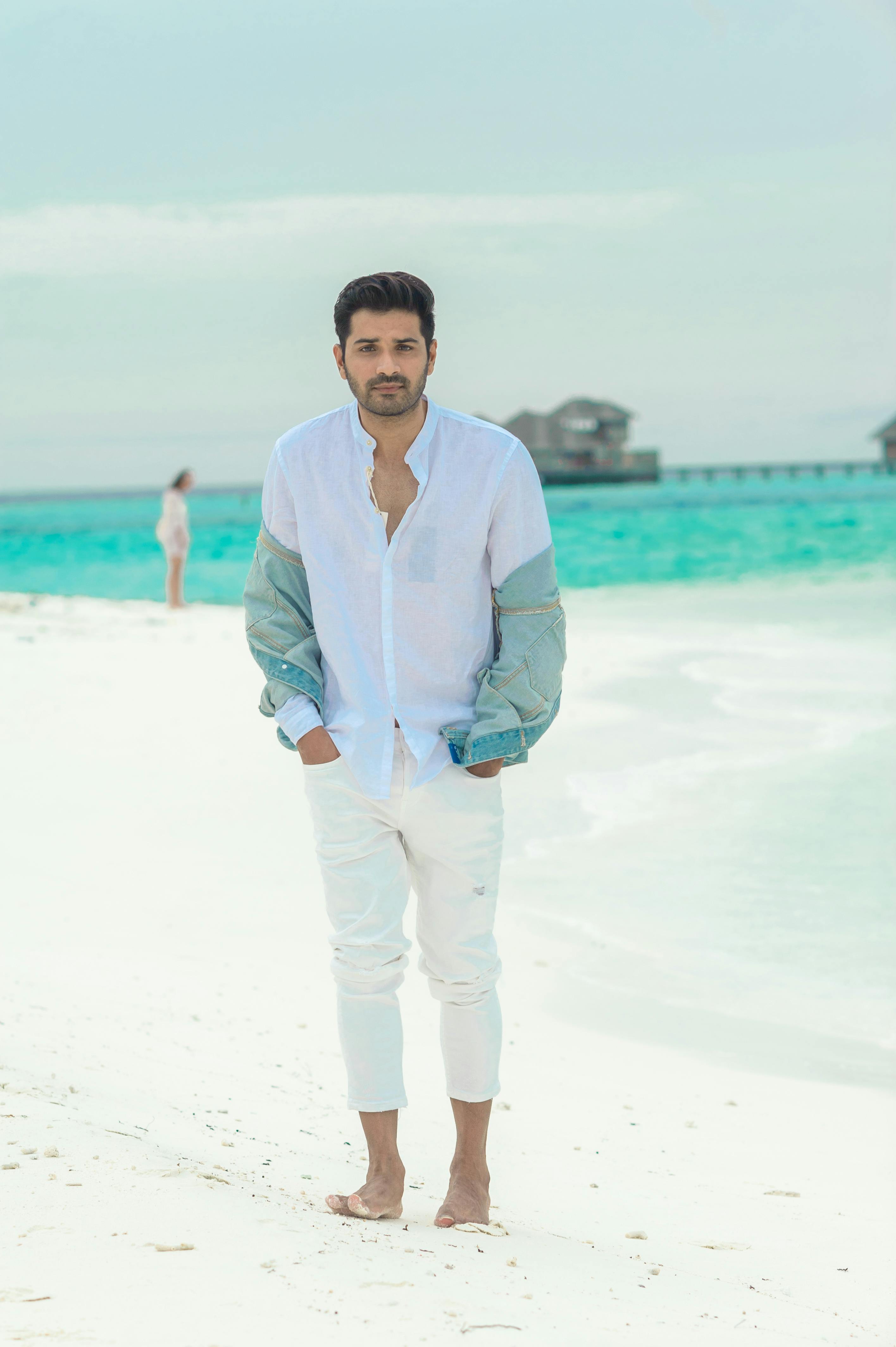 Fashionable man on a tropical beach in the Maldives, showcasing vacation style.