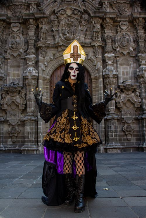 Free Person in ornate gothic attire posing at a historic church entrance. Stock Photo