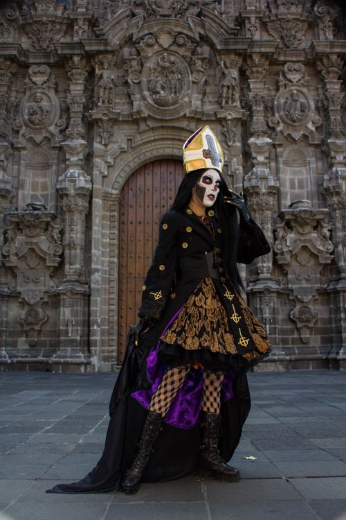 Free Person in gothic costume poses in front of ornate baroque building, exuding dramatic flair. Stock Photo