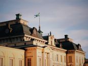 Drottningholm Palace with Swedish flag against a clear autumn sky. Iconic Swedish architecture.